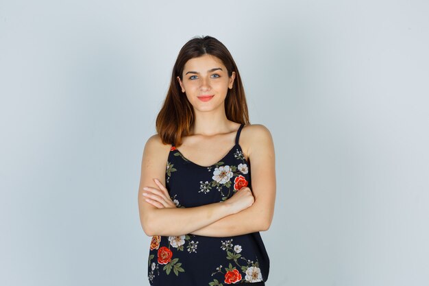 portrait-young-lady-holding-arms-folded-blouse-looking-cheerful-front-view_176474-90633
